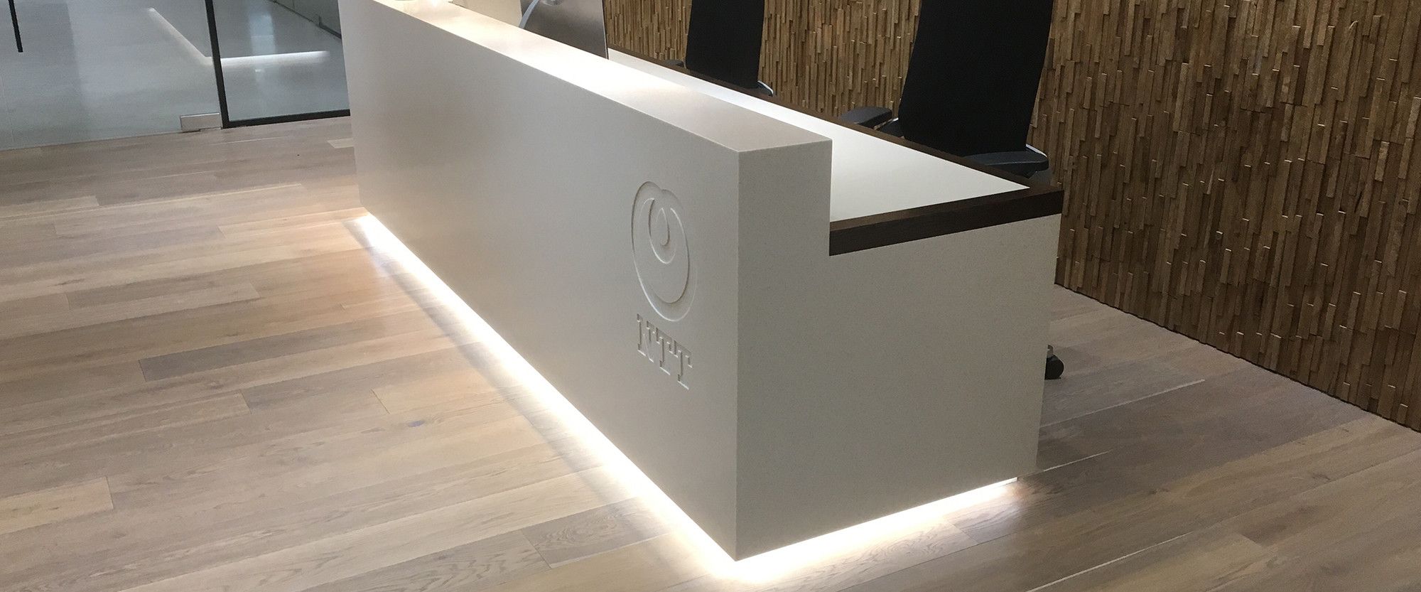 Reception area desk signage for Japanese technology company NTT. Internal signage and welcome areas play a key role extending the brand from outside to inside.